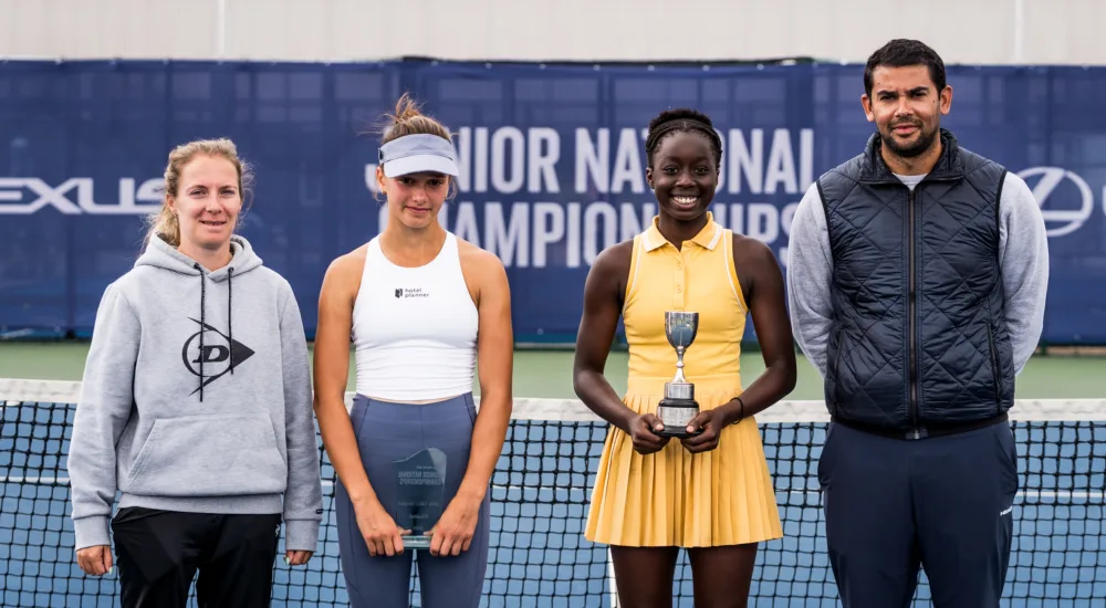 tennis participants pose for a picture with a trophy